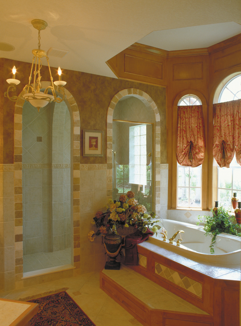 Master bathroom's shower with decorative tile and lavish whirlpool tub.
