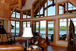 082S-0001 Great room with two-story ceiling and rustic beams.